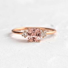 a pink diamond ring with three diamonds on it