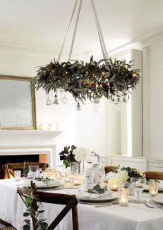 a dining room table is set with white linens and place settings for dinner guests