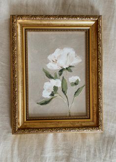 a painting of white flowers in a gold frame