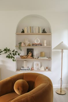 a living room filled with furniture and a book shelf next to a wall mounted clock