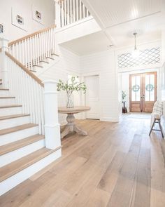 a white house with wood floors and stairs