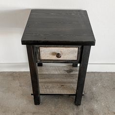 a small wooden table with two drawers on one side and an open drawer on the other