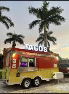 a taco truck parked in front of palm trees