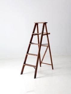 a wooden ladder leaning up against a white wall