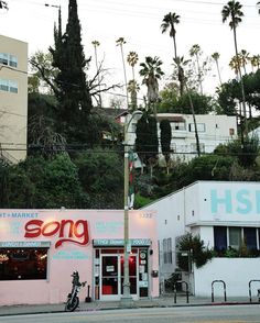 a pink building with neon lights and palm trees in the background