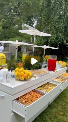 an outdoor buffet with oranges, lemons and other foods on it's side