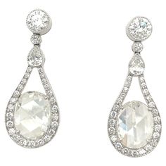 A beautifully designed pair of platinum and diamond drop earrings. The earrings are set with 2.89 carat oval rose cut diamonds. The mandolin style frame setting has .23 carats pear shaped diamonds, and .90 carats round diamonds. The combination of the 2 different diamond cuts catch the light just perfectly. The post back earrings measure 1.25" x .50". Stamped PLAT Luxury Vintage Single Cut Diamond Earrings, Luxury Fine Jewelry Chandelier Earrings With Prong Setting, Exquisite Oval Diamond Earrings With Accents, Exquisite Oval Brilliant Cut Diamond Earrings, Luxury Gia Certified Oval Diamond Earrings, Exquisite Oval Diamond Earrings With Brilliant Cut, Formal Pear-shaped Diamond Earrings With Single Cut Diamonds, Pear-shaped Rose Cut Diamond Earrings For Wedding, Oval Diamond Bridal Earrings For Anniversary