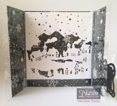 an open card with black and white paper cut out of it's sides, featuring snowflakes