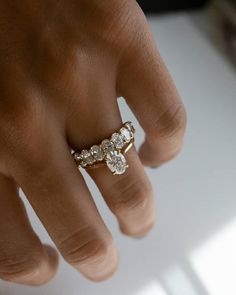 a woman's hand with a gold ring and three diamond rings on top of it