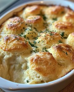 a casserole dish with cheese and herbs in it on a wooden table top