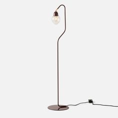 a floor lamp with a light bulb on it's end and a cord attached to the base