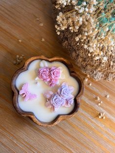 some pink flowers are floating in a bowl