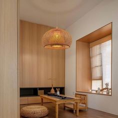 a wooden table sitting under a light fixture in a room