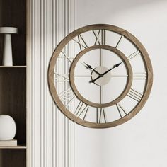 a wall clock with roman numerals is hanging on the wall next to a bookshelf