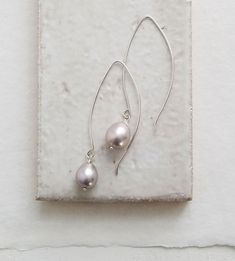 These linear drop gray pearl earrings will elevate any outfit. Lightweight, hand formed ear wires drop these pearls right along side the face, creating shimmering accents. Plump and substantial sized these are a fresh take on classic pearl earrings.



Sleek and simple in sterling silver or choose 14kt gold fill for a rich contrast – either way these are chic pearl earrings you’ll adore.