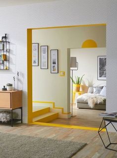 a living room with white walls and yellow trim on the door, carpeted floor