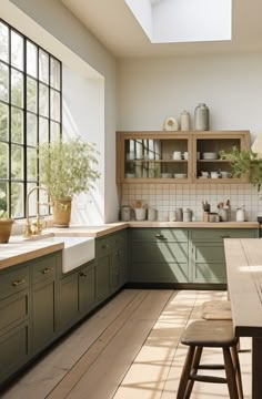 a kitchen filled with lots of green cabinets and counter top space next to a window