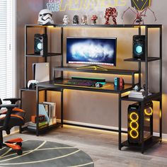 a computer desk with a monitor and speakers on it in front of a star wars sign