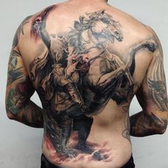 the back of a man with tattoos on his body