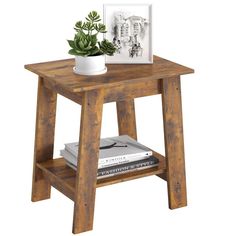 a small wooden table with a potted plant next to it on top of books