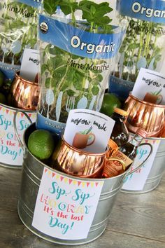 several metal buckets filled with plants and cards on top of a wooden table next to each other