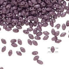 purple seed beads are scattered on a white surface