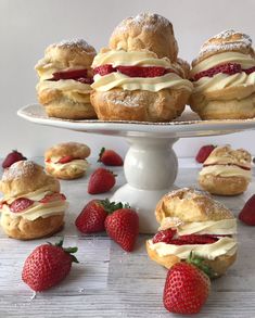 strawberry shortcakes with cream cheese frosting and strawberries on a cake stand