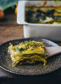 a plate with some food on it and a spoon in front of the casserole