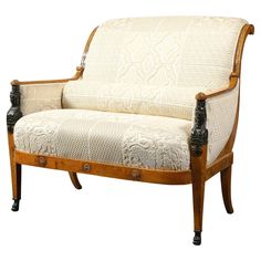 an old fashioned wooden couch with white upholstered fabric