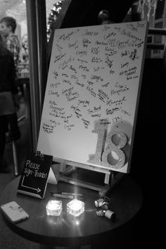 a white board with writing on it sitting on top of a table next to candles