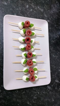 small appetizers with flowers are arranged on a white plate, ready to be eaten