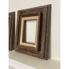 two wooden frames sitting on top of a white mantle