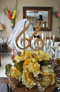 there is a cake topper with a musical note on it and flowers in the middle