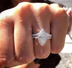 a close up of a person wearing a ring on their finger with a diamond in the middle