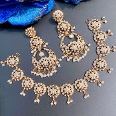 Featuring a dainty floral necklace and tall chandbali danglers made on sterling silver metal with gold plating. It has been embellished with freshwater pearls. The necklace will be supplied with an adjustable length gold plated back-chain. The earrings close with a bombay screw. Elegant Chandbali Jewelry For Reception, Elegant Gold Pearl Necklace With Latkans, Elegant Round Kundan Necklace With Latkans, Gold Necklace With Matching Earrings For Reception, White Hand Set Jewelry For Eid, Elegant Pearl Necklace With Latkans For Festivals, Elegant Chandbali Bridal Necklace With Latkans, Intricate Dangle Jewelry For Reception, Elegant Bridal Necklace With Latkans For Party