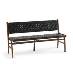 a wooden bench with black leather upholstered seat and back rests against a white background