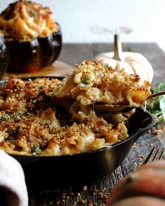 a casserole dish filled with macaroni and cheese, garnished with parsley