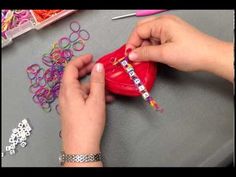 a woman is making bracelets out of rubber bands and plastic beads with her hands