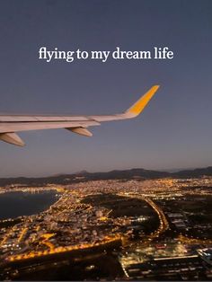 an airplane wing with the words flying to my dream life above it at night time