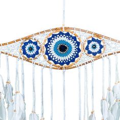 a blue and white dream catcher with feathers hanging from it