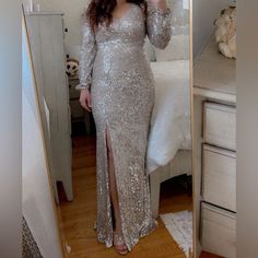 a woman taking a selfie in a mirror wearing a long silver sequin dress