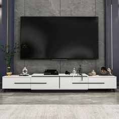 a large flat screen tv mounted to the side of a white cabinet in a living room