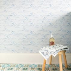 a table with a cloth on it in front of a wallpapered room that has waves painted on it