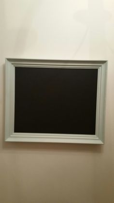 an empty white frame hanging on the wall