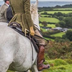 two people are riding horses in the countryside