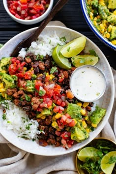 a bowl filled with rice, beans and avocado next to two bowls of salsa