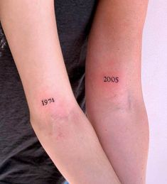 two people with tattoos on their arms that say year 2007 and the other is written in black ink