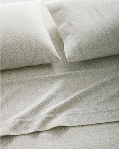 an unmade bed with white sheets and pillowcases on top of each other