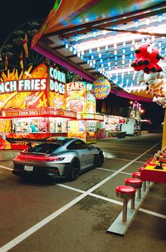 a car driving down a street next to a carnival