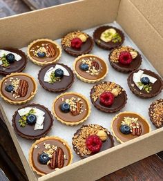 a box filled with lots of desserts on top of a wooden table